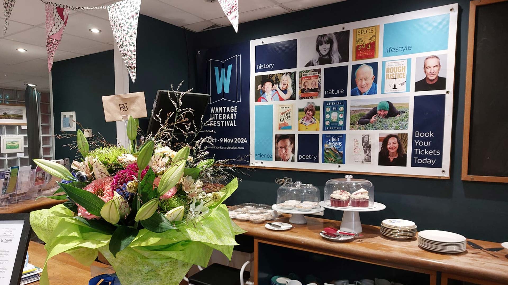 Wantage Literary Festival advert alongside some cakes and plates.