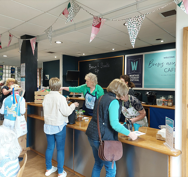 Brews and Books Cafe at Wantage Literary Festival. There are staff members manning the til and serving customers.