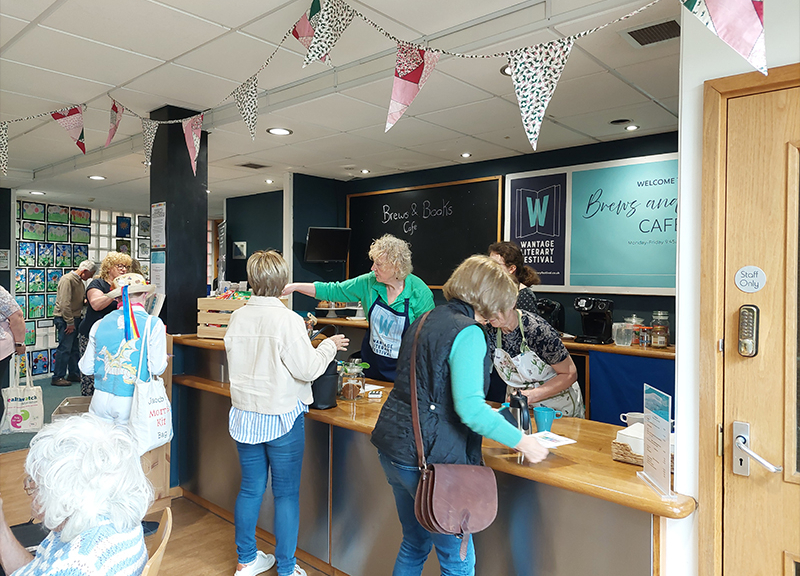 Brews and Books Cafe at Wantage Literary Festival. There are staff members manning the til and serving customers.