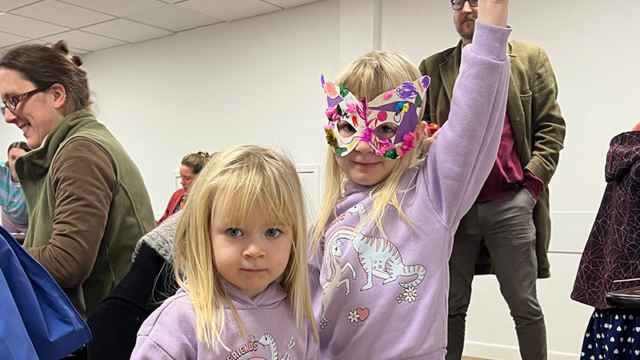 A child wearing a decorative mask.