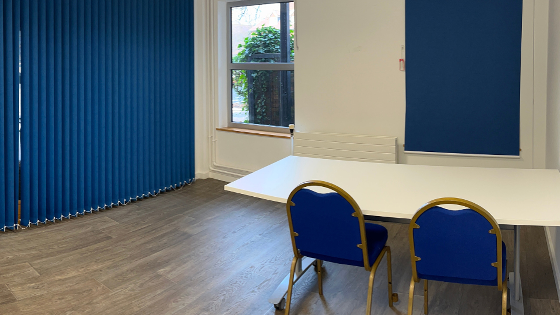 A meeting room space with a singular table and two chairs.