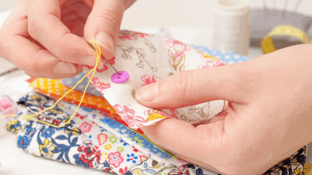 picture of hands, hand stitching fabric